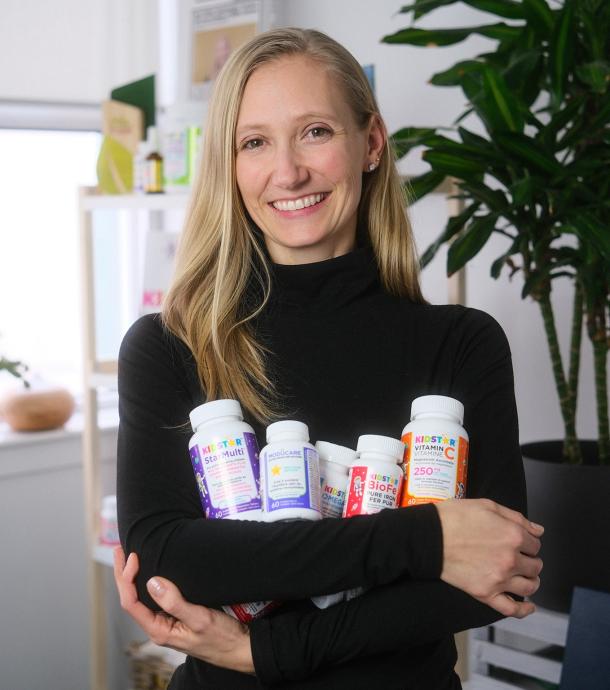 Founder Caitlyn KidStar Nutrients holding bottles of nutraceuticals
